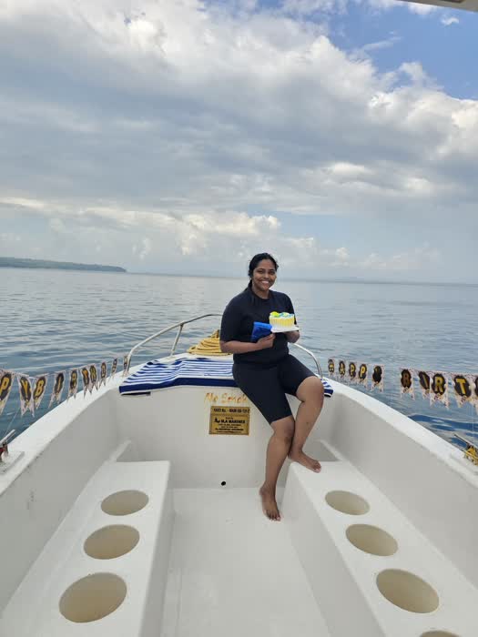 A diver sitting on the side of the dive boat on a calm morning