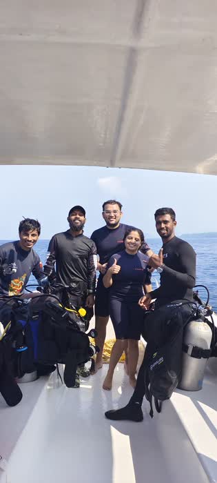 A group of divers in wetsuits and gear getting ready on the boat